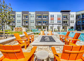 Thumbnail 5 of 65 - A pool area with orange chairs and a fountain in the middle.