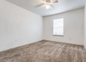 Thumbnail 12 of 13 - a bedroom with white walls and a ceiling fan at Rosillo Creek Apartments, Texas