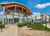 Thumbnail 20 of 27 - a gray building with a wooden roof and a grassy area in front of it at The Landings at Brooks City-Base, Texas, 78235