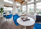 Thumbnail 19 of 27 - a living room with a white table and blue chairs at The Landings at Brooks City-Base, San Antonio