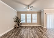 Thumbnail 4 of 36 - A room with a ceiling fan and a plant at Rosemary Apartments, Conroe, TX