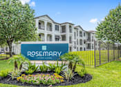 Thumbnail 12 of 36 - A sign for Rosemary Luxury Living in front of a building at Rosemary Apartments, Conroe, TX, 77384