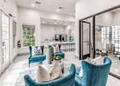 Thumbnail 13 of 36 - A living room with blue chairs and a white couch at Rosemary Apartments, Conroe, TX