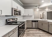 Thumbnail 22 of 36 - A modern kitchen with a stove, microwave, and dishwasher at Rosemary Apartments, Texas
