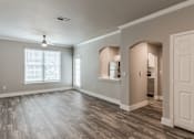 Thumbnail 2 of 36 - A spacious room with wooden flooring and a white door at Rosemary Apartments, Conroe, TX, 77384