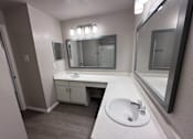 Thumbnail 10 of 17 - A bathroom with a sink, mirror, and cabinet.