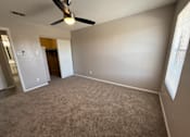 Thumbnail 11 of 17 - A room with a ceiling fan and carpeted floor.