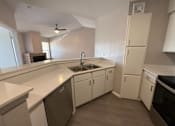 Thumbnail 2 of 17 - A kitchen with white cabinets and a black dishwasher.