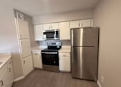 Thumbnail 12 of 17 - A kitchen with a stainless steel refrigerator, oven, and microwave.
