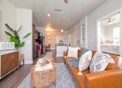 Thumbnail 15 of 27 - a living room with a couch and a coffee table at The Landings at Brooks City-Base, San Antonio, TX, 78235