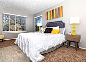 Thumbnail 6 of 16 - A bedroom with a bed, nightstand, and chair.
