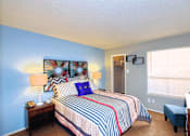 Thumbnail 16 of 16 - A bedroom with a bed, nightstand, and window.