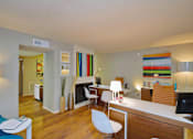 Thumbnail 8 of 16 - a living room with a desk and a fireplace