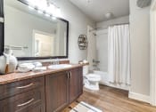 Thumbnail 16 of 27 - a bathroom with a large mirror and a white shower curtain at The Landings at Brooks City-Base, Texas, 78235