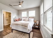 Thumbnail 14 of 27 - a bedroom with a bed and a ceiling fan at The Landings at Brooks City-Base, Texas