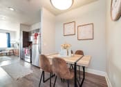 Thumbnail 10 of 27 - a dining area with a table and chairs and a kitchen in the background at The Landings at Brooks City-Base, San Antonio, TX, 78235