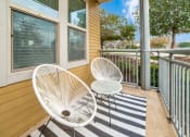Thumbnail 7 of 27 - a balcony with two chairs and a table at The Landings at Brooks City-Base, San Antonio, TX, 78235