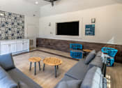Thumbnail 6 of 36 - A living room with grey couches and a wooden coffee table at Rosemary Apartments, Conroe, TX, 77384