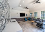 Thumbnail 30 of 36 - A modern living room with a grey sofa and a patterned wallpaper at Rosemary Apartments, Conroe, TX