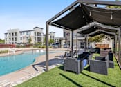 Thumbnail 32 of 72 - a pool with lounge chairs and awnings next to a swimming pool at Radius on Grove, Austin, TX, 78741