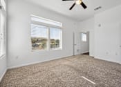 Thumbnail 12 of 72 - an empty living room with carpet and a ceiling fan at Radius on Grove, Austin, 78741