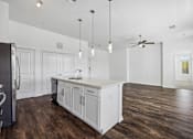 Thumbnail 10 of 72 - an open kitchen and living room with white walls and wood floors at Radius on Grove, Texas