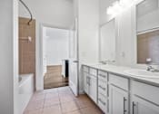 Thumbnail 27 of 72 - a bathroom with white cabinets and a large mirror and a tub at Radius on Grove, Austin