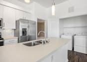 Thumbnail 28 of 72 - a white kitchen with stainless steel appliances and a white counter top at Radius on Grove, Austin