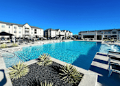 Thumbnail 1 of 25 - a large swimming pool with buildings in the background at The Fitzroy San Marcos, San Marcos, Texas
