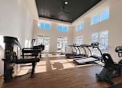 Thumbnail 5 of 25 - a gym with cardio equipment and windows in a building at The Fitzroy San Marcos, Texas