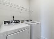Thumbnail 23 of 25 - a white laundry room with two washes and a dryer at The Fitzroy San Marcos, San Marcos, TX