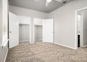 Thumbnail 22 of 35 - Spacious bedroom with dual closets and carpet at Houston Street Townhomes Apartments, San Antonio, TX