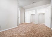 Thumbnail 12 of 35 - Empty bedroom with carpet and dual closets at Houston Street Townhomes Apartments, San Antonio