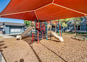 Thumbnail 4 of 35 - Playground with shade canopy and slides at Houston Street Townhomes Apartments, San Antonio