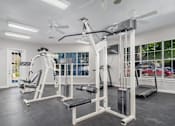 Thumbnail 26 of 35 - Fitness center with weight machines and cardio equipment at Houston Street Townhomes Apartments, San Antonio, 78220