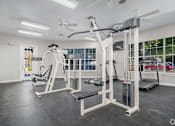 Thumbnail 7 of 35 - Fitness center with weight machines and cardio equipment at Houston Street Townhomes Apartments, San Antonio, Texas