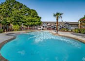 Thumbnail 5 of 35 - Resort style swimming pool with palm tree at Houston Street Townhomes Apartments, San Antonio, TX
