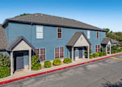 Thumbnail 2 of 35 - Blue townhome buildings with peaked entry porches at Houston Street Townhomes Apartments, San Antonio, Texas