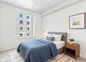 Thumbnail 19 of 29 - A bedroom with a large bed and a window overlooking a building.