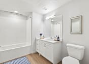 Thumbnail 17 of 29 - A white bathroom with a toilet, sink, and bathtub.