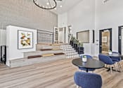Thumbnail 9 of 29 - A modern living room with a staircase and a painting on the wall.