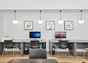Thumbnail 7 of 29 - A modern office with a desk, chairs, and a computer monitor.