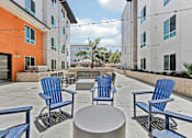 Thumbnail 11 of 29 - Four blue chairs and a table are on a patio.