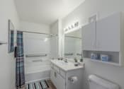 Thumbnail 3 of 11 - A white bathroom with a toilet, sink, and shower.