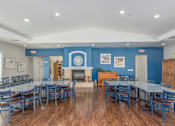 Thumbnail 6 of 11 - A large dining room with a fireplace and blue walls.