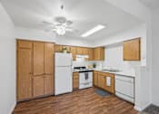 Thumbnail 7 of 11 - A kitchen with wooden cabinets and white appliances.