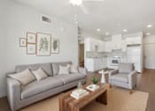 Thumbnail 1 of 12 - A living room with a grey couch and a coffee table.