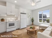 Thumbnail 10 of 12 - A well-lit studio apartment with a kitchen area and a living room.