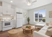 Thumbnail 9 of 12 - A modern kitchen with white appliances and a dining area with a round table.