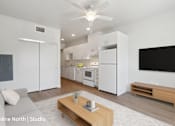 Thumbnail 11 of 12 - A modern living room with a grey sofa and a wooden coffee table.